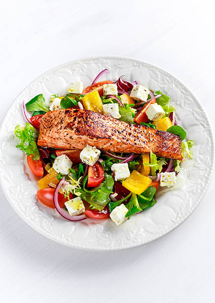 istock Fried Salmon steak with fresh vegetables salad, feta cheese. concept 637001040