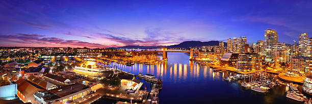 Vancouver harbor view Vancouver harbor view with urban apartment buildings and bay boat at dusk in Canada. vancouver at night stock pictures, royalty-free photos & images