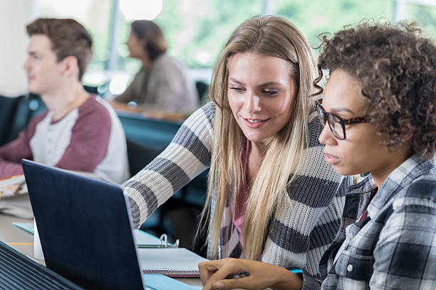 istock Female college friends use laptop in class 637015138