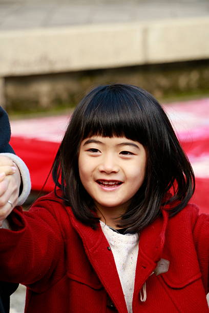 Little Japanese girl holding hands with parent