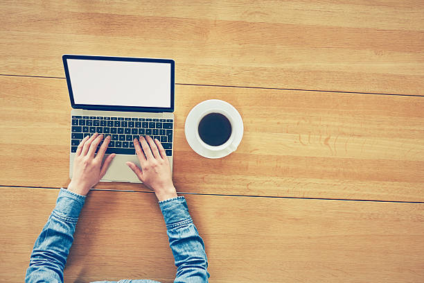 istock Female blogger using laptop by coffee cup on table 637017600