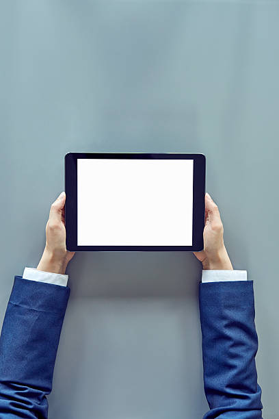 istock Close-up of female hands using digital tablet on gray table 637018464