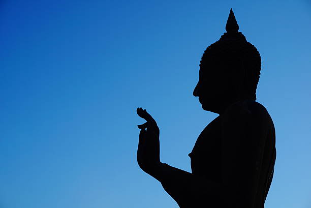 istock Silhouette Buddha statue with blue sky background 637019460