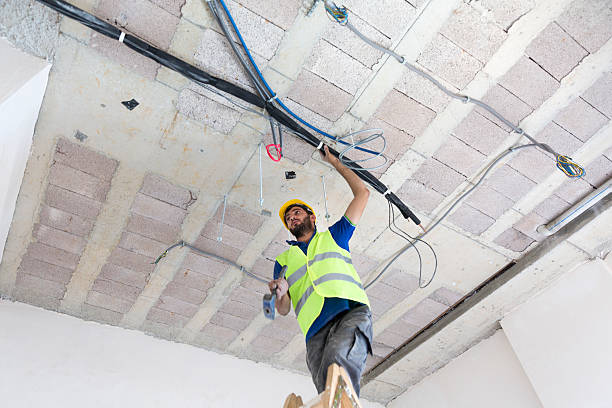 istock Electrician fitting air conditioning to office interior 637019800