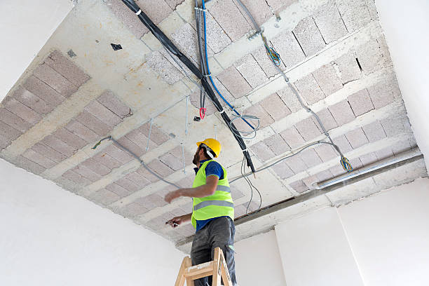 istock Electrician fitting air conditioning to office interior 637019966