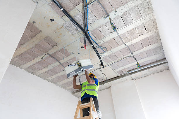 istock Electrician fitting air conditioning to office interior 637020764