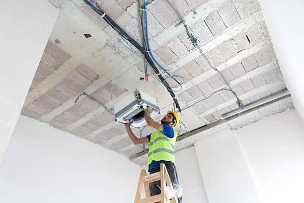 istock Electrician fitting air conditioning to office interior 637021202