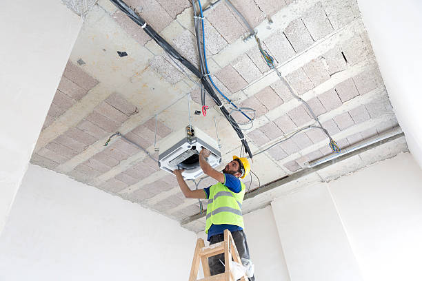 istock Electrician fitting air conditioning to office interior 637021406