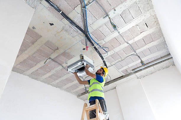 istock Electrician fitting air conditioning to office interior 637021590