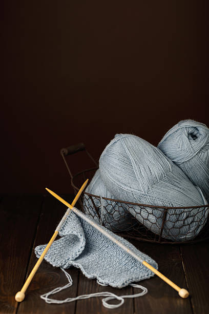 istock Knitting from light blue yarn on dark brown wooden background. 637023454