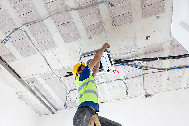 istock Electrician fitting air conditioning to office interior 637023902