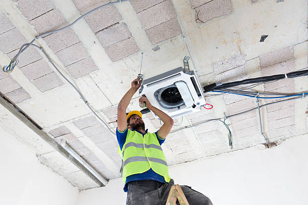 istock Electrician fitting air conditioning to office interior 637024132