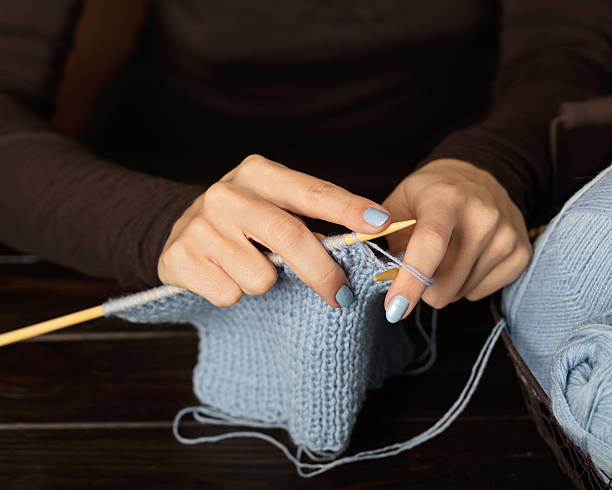 istock Female hands knitting from light blue yarn. 637024168