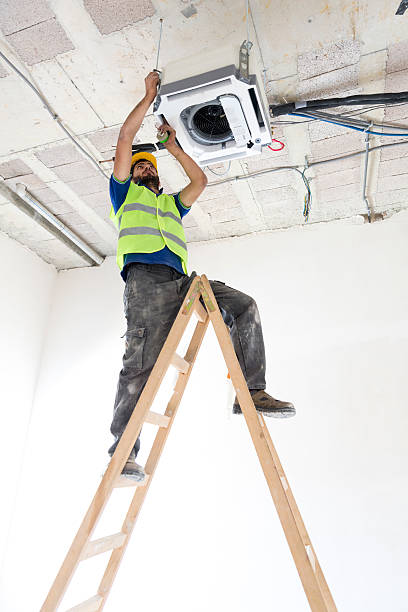 istock Electrician fitting air conditioning to office interior 637024808