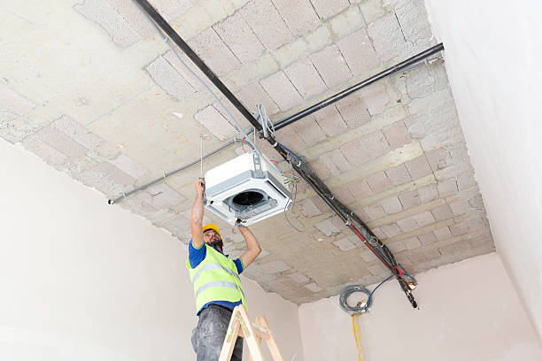 istock Electrician fitting air conditioning to office interior 637025638