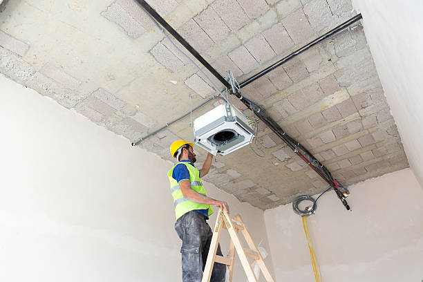 istock Electrician fitting air conditioning to office interior 637026306