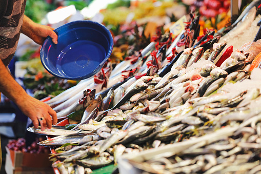 People shopping for fresh fish from a street market stall trader in the Central district of Kadikoy,Istanbul.