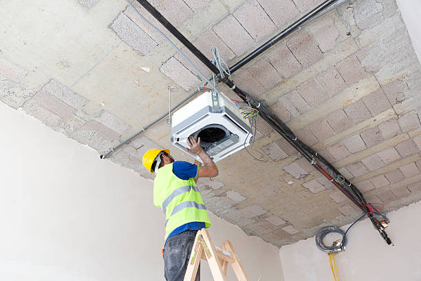 istock Electrician fitting air conditioning to office interior 637026648