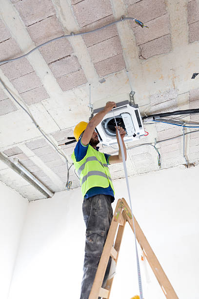 istock Electrician fitting air conditioning to office interior 637027030