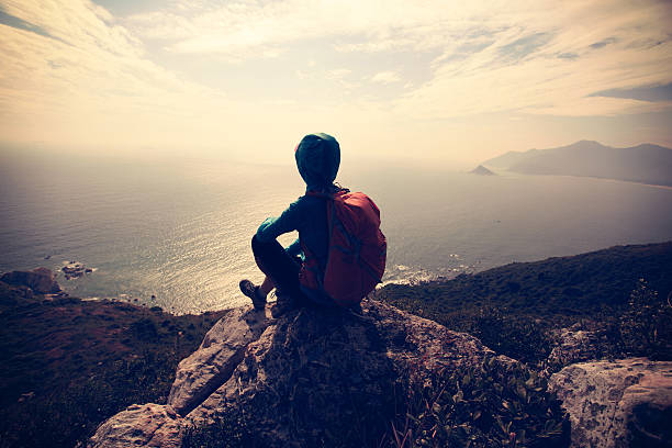istock successful hiker on seaside mountain peak rock 637027108