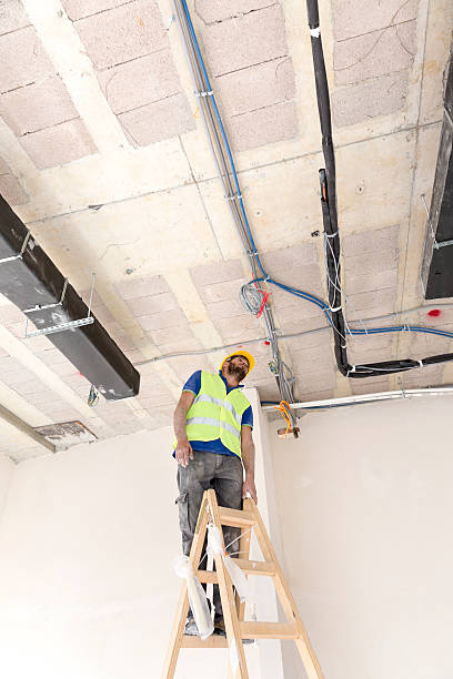 istock Electrician fitting air conditioning to office interior 637027330