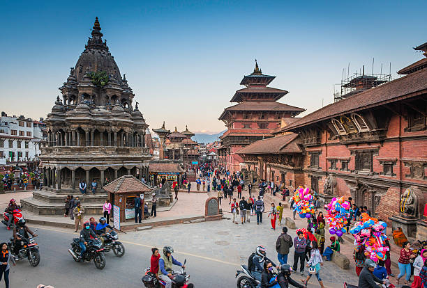 Kathmandu crowds of people outside temples Patan Durbar Square Nepal Kathmandu, Nepal - November 7, 2016: Clear blue skies over the wooden temples and shrines as crowds of visitors pass the historic monuments of Patan Durbar Square, a UNESCO World Heritage Site in the heart of Kathmandu, Nepal's vibrant capital city.  gompa stock pictures, royalty-free photos & images
