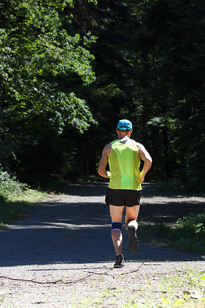 istock Male runner running on forest road 637031566