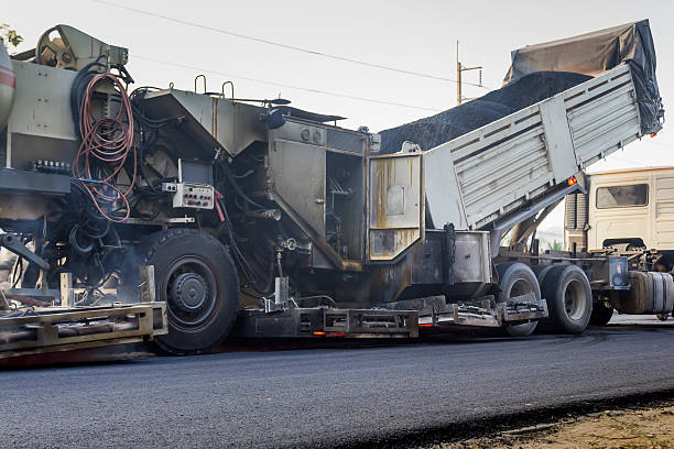 istock truck is unloading asphalt to machine for repair road 637032060