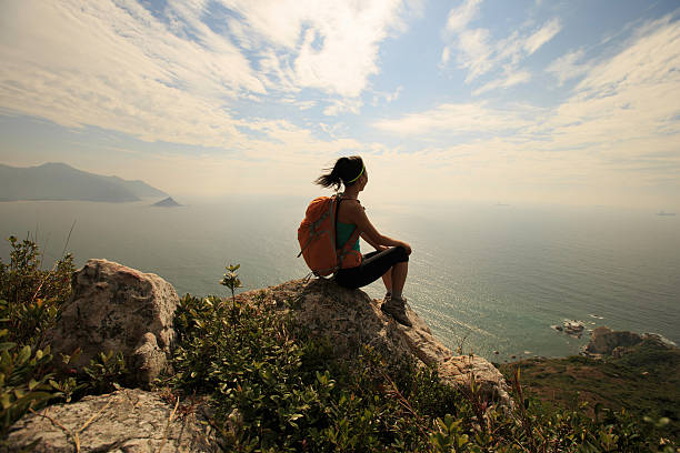 istock successful hiker on seaside mountain peak rock 637035842