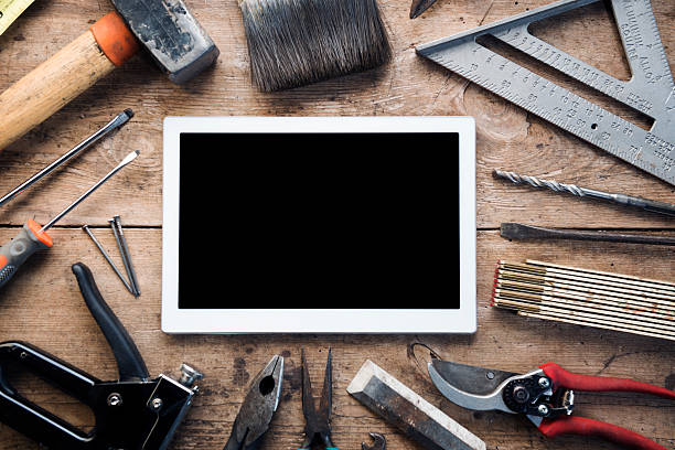 gli utensili a mano da costruzione circondano un tablet digitale - work tool computer repairing internet foto e immagini stock