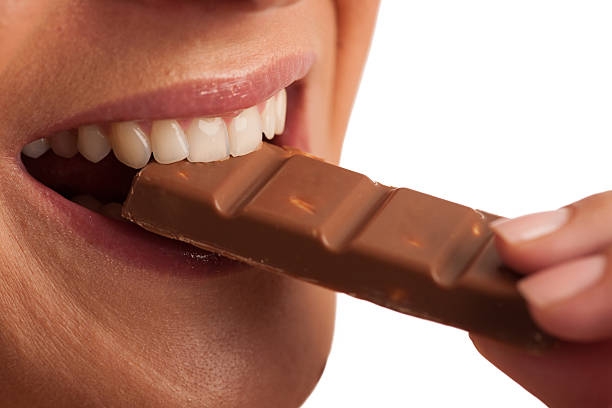 istock Beautiful young woman eats chocolate isolated over white backgro 637036782