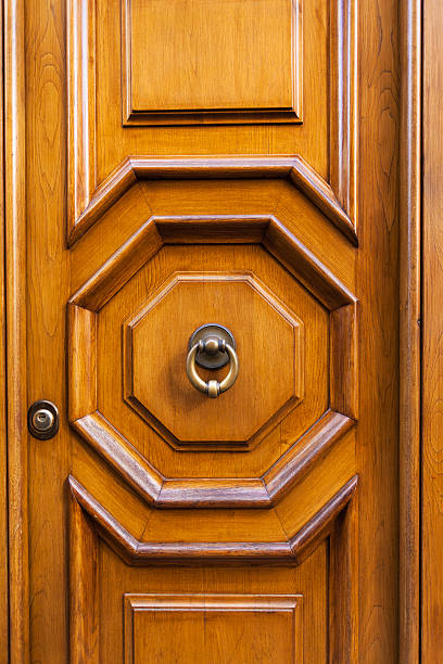 istock wood door with brass ring door knocker in Rome 637038376