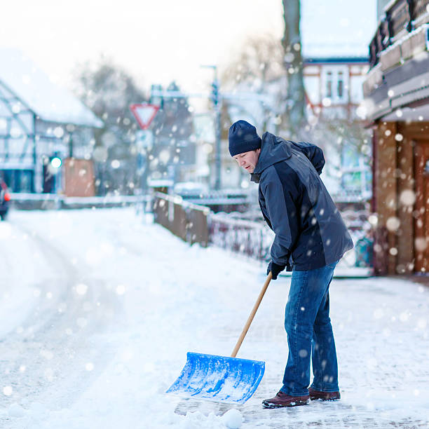 istock Man with snow shovel cleans sidewalks in winter 637039932
