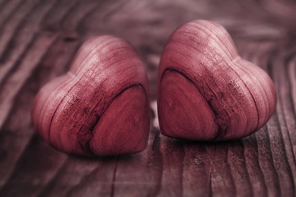 Background in pastel red with two hearts of wood for love greetings