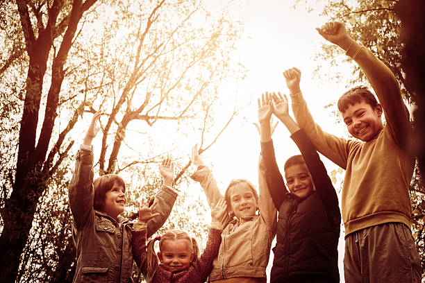 istock Cheerful children with raised hands and looking at the camera. 637047900