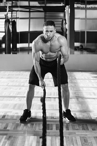 istock Young Man Battling Ropes At Gym Workout Exercise 637050236