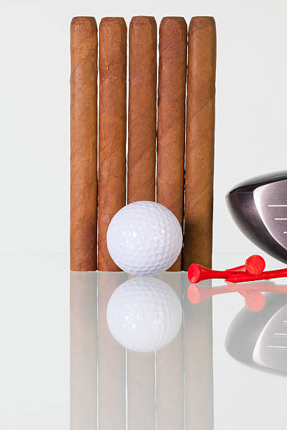 istock Golf driver and different cigars on a glass desk 637053950