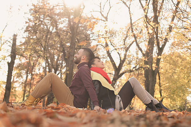 Cute couple in the park. Couple in the park sitting  on the leaves. person falling backwards stock pictures, royalty-free photos & images