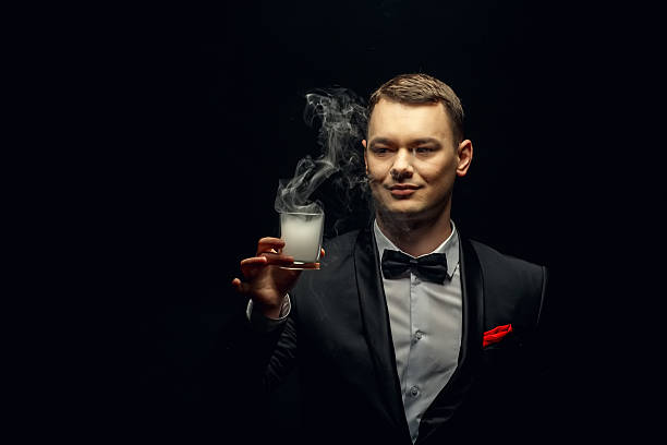istock Illusionist man makes smoke his hand on a dark background. 637060574