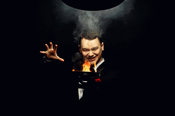 istock Young brunette magician in costume performing flame tricks 637061572