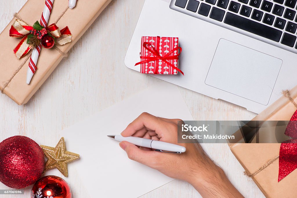 Christmas card writing with gift box and computer Christmas card writing with gift box and computer. View from above. Christmas Stock Photo