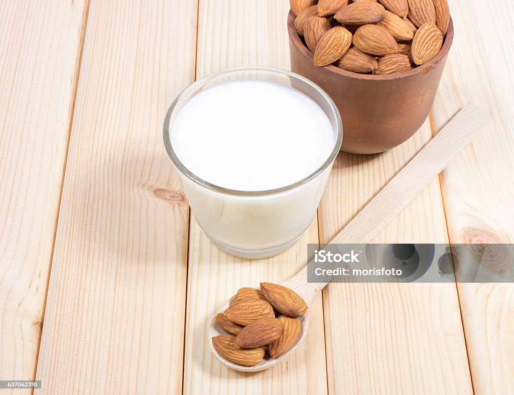 Almond milk with almond on a wooden table. Almond milk with almond on a wooden table - vegan drink. Almond Stock Photo