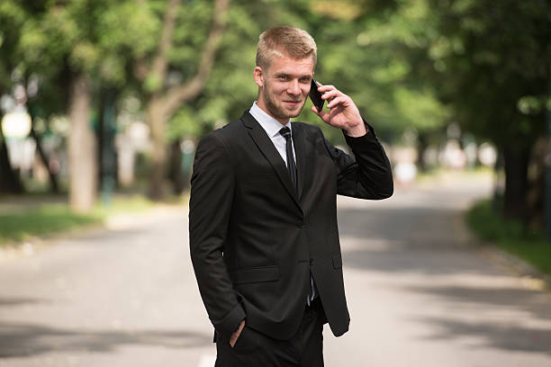 istock Businessman Talking On Telephone Outdoors In Park 637065176