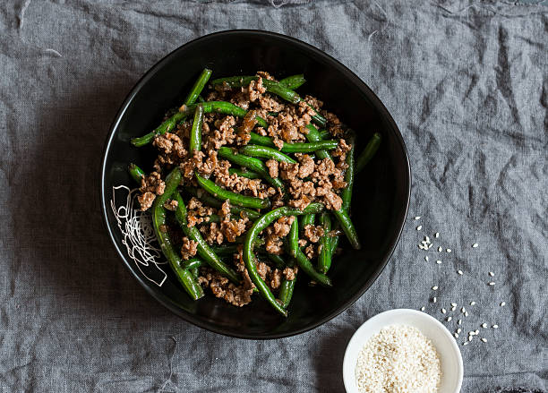 wieprzowina i fasola szparagowa wymieszać smażyć na ciemnym stole - appetizer bean beef bowl zdjęcia i obrazy z banku zdjęć