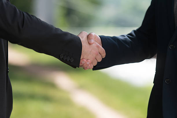 istock Businessman Shaking Hands Outside The Office 637066422