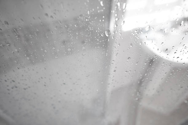 Real water drops and steam on shower glass box