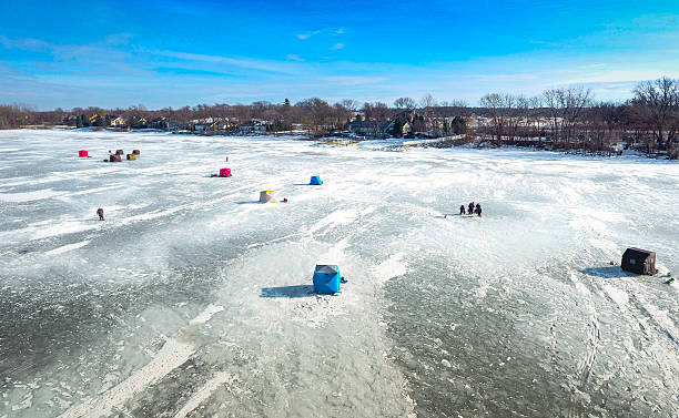 Ice fishing on a warm winter day One foot of ice on the bay is enough for the ice fishermen to get out and do their thing on the Bay of Green Bay. Generally they are fishing for perch and walleye, but there are other species. hut stock pictures, royalty-free photos & images