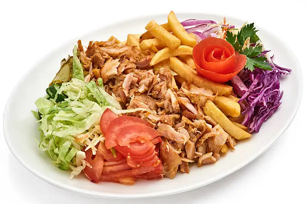 Doner kebab on a plate with french fries and salad