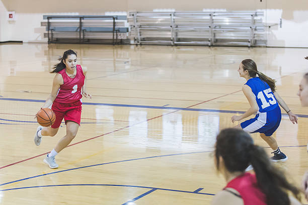 weibliche high-school-basketballspielerin dribbelt zu reifen - school gymnasium gym basketball court school stock-fotos und bilder