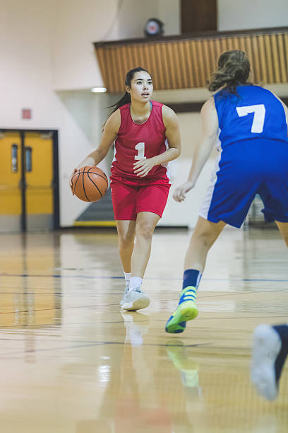 weibliche high-school-basketballspielerin dribbelt zu reifen - school gymnasium gym basketball court school stock-fotos und bilder